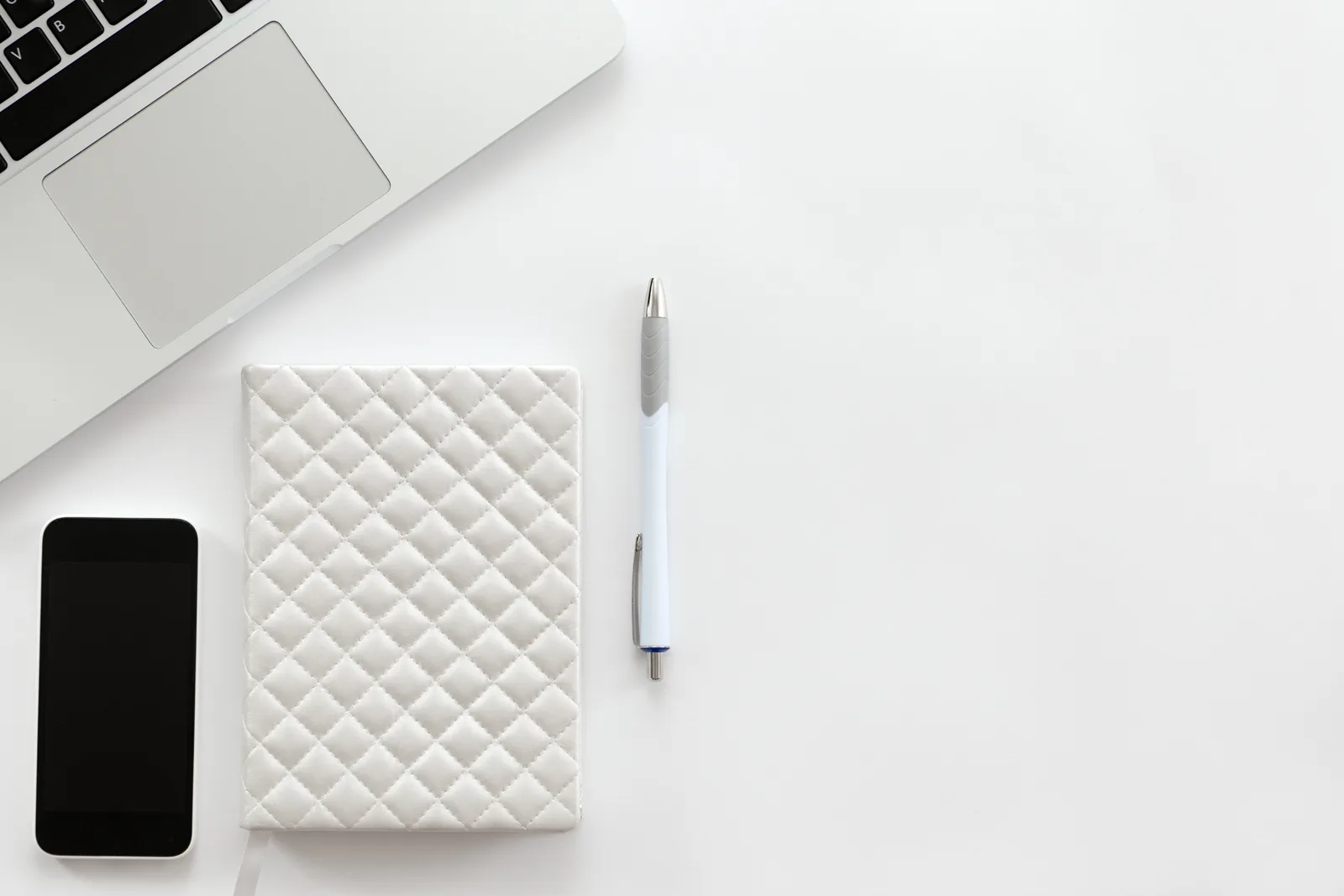 Bureau minimaliste blanc avec laptop et smartphone — Le Web Studio, création de sites web multilingues pour le tourisme mexicain